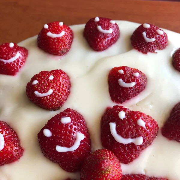 selective focus. Strawberry pie garnished with fresh strawberries. Homemade strawberries cake made from meringue cake and cream with strawberries. Decorated with icing and berries. birthday cake with smiley face.