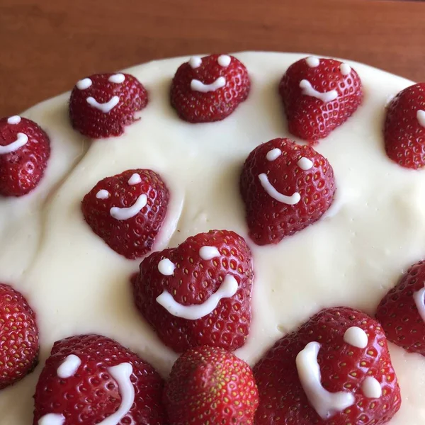 selective focus. Strawberry pie garnished with fresh strawberries. Homemade strawberries cake made from meringue cake and cream with strawberries. Decorated with icing and berries. birthday cake with smiley face.