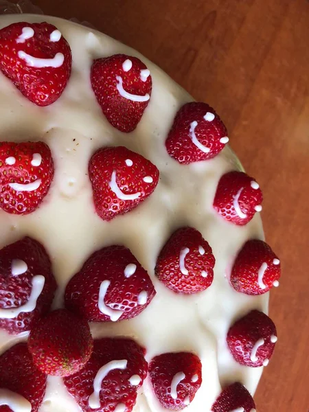 selective focus. Strawberry pie garnished with fresh strawberries. Homemade strawberries cake made from meringue cake and cream with strawberries. Decorated with icing and berries. birthday cake with smiley face.