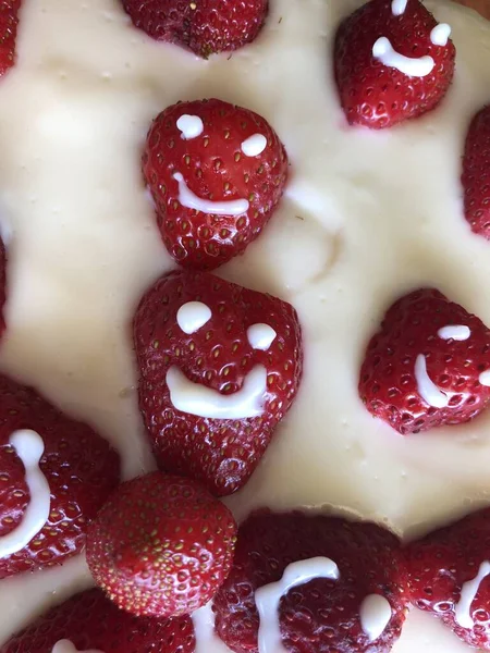 selective focus. Strawberry pie garnished with fresh strawberries. Homemade strawberries cake made from meringue cake and cream with strawberries. Decorated with icing and berries. birthday cake with smiley face.