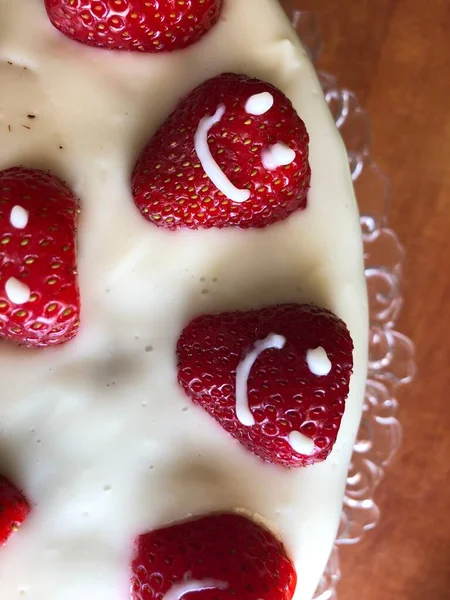 selective focus. Strawberry pie garnished with fresh strawberries. Homemade strawberries cake made from meringue cake and cream with strawberries. Decorated with icing and berries. birthday cake with smiley face.