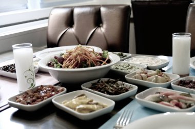 Traditional Turkish meze and appetizers on dinner table. The taste of Turkish Rak is also different. They are a milestone in Turkish culture. Close up view of friends having fun and toasting with rak. Celebrating concept at the table. aka uzo.