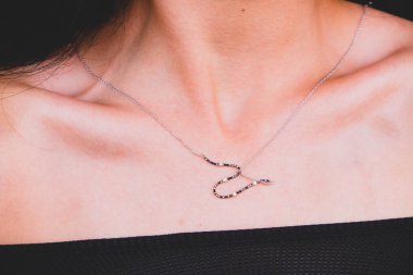 The girl gently touches the necklace around her neck. Wedding morning of the bride. Advertising decorations. The woman goes on a date. Diamond jewellery. Diamond necklace on woman