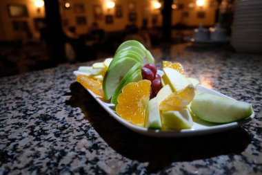 Taze sebze ve yenilebilir çiçek. Sağlıklı çiğ meyve çeşitleri. Beyaz tabakta, kapalı masada, seçici bir odak noktası olan çiğ meyve çileği tabağı..