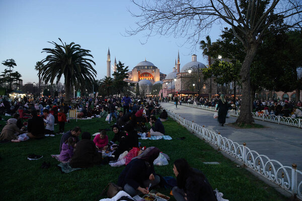 ИСТАНБУЛ, ТУРКИЙ - 09 апреля 2022 года: Люди ждут, чтобы прервать пост на площади Султанахмет во время рамадана.