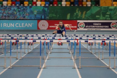 İSTANBUL, TURKEY - 11 Aralık 2021: Türkiye Atletizm Federasyonu Olimpiyat Eşiği sırasında 60 metre engelli koşan tanımlanamayan sporcu