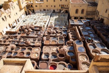 FEZ, MOROCCO - 31 Ekim 2021: İnsanlar Fez City 'de ziyaret etmek için en popüler yerlerden biri olan Chouara Tannery' de deri boyuyorlar