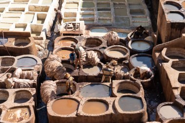 FEZ, MOROCCO - 31 Ekim 2021: İnsanlar Fez City 'de ziyaret etmek için en popüler yerlerden biri olan Chouara Tannery' de deri boyuyorlar