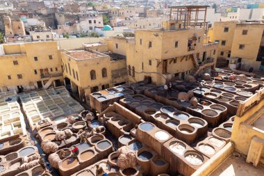 FEZ, MOROCCO - OCTOBER 31, 2021: People dyeing leather in Chouara Tannery where one of the most popular place to visit in Fez City