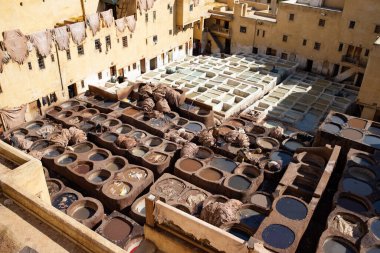 FEZ, MOROCCO - 31 Ekim 2021: İnsanlar Fez City 'de ziyaret etmek için en popüler yerlerden biri olan Chouara Tannery' de deri boyuyorlar