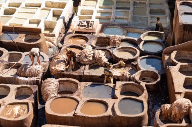FEZ, MOROCCO - 31 Ekim 2021: İnsanlar Fez City 'de ziyaret etmek için en popüler yerlerden biri olan Chouara Tannery' de deri boyuyorlar