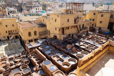 FEZ, MOROCCO - OCTOBER 31, 2021: People dyeing leather in Chouara Tannery where one of the most popular place to visit in Fez City