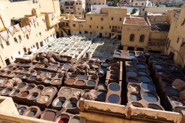 FEZ, MOROCCO - 31 Ekim 2021: İnsanlar Fez City 'de ziyaret etmek için en popüler yerlerden biri olan Chouara Tannery' de deri boyuyorlar