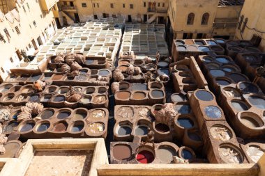 FEZ, MOROCCO - 31 Ekim 2021: İnsanlar Fez City 'de ziyaret etmek için en popüler yerlerden biri olan Chouara Tannery' de deri boyuyorlar