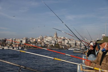 İSTANBUL, TURKEY - 23 Ekim 2021: Galata Köprüsü üzerinde balık tutan insanlar