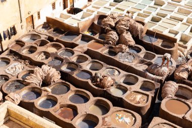FEZ, MOROCCO - 31 Ekim 2021: İnsanlar Fez City 'de ziyaret etmek için en popüler yerlerden biri olan Chouara Tannery' de deri boyuyorlar