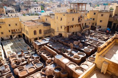 FEZ, MOROCCO - OCTOBER 31, 2021: People dyeing leather in Chouara Tannery where one of the most popular place to visit in Fez City