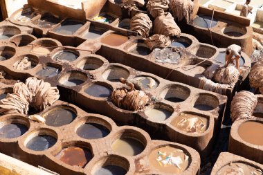 FEZ, MOROCCO - 31 Ekim 2021: İnsanlar Fez City 'de ziyaret etmek için en popüler yerlerden biri olan Chouara Tannery' de deri boyuyorlar