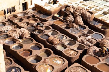 FEZ, MOROCCO - 31 Ekim 2021: İnsanlar Fez City 'de ziyaret etmek için en popüler yerlerden biri olan Chouara Tannery' de deri boyuyorlar