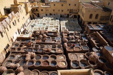 FEZ, MOROCCO - 31 Ekim 2021: İnsanlar Fez City 'de ziyaret etmek için en popüler yerlerden biri olan Chouara Tannery' de deri boyuyorlar