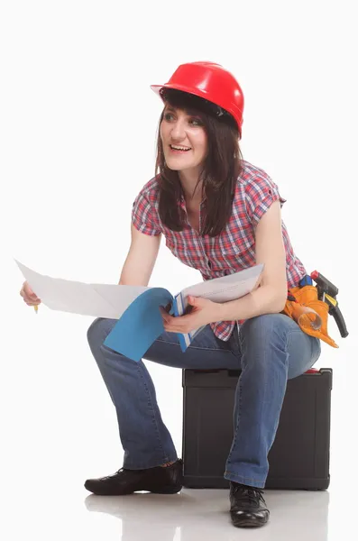 Woman in a helmet sits and reads documents — Stock Photo, Image