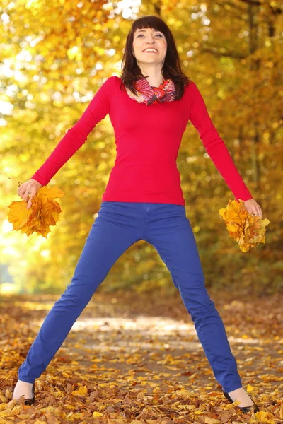 Женщина с осенними листьями в руке — стоковое фото