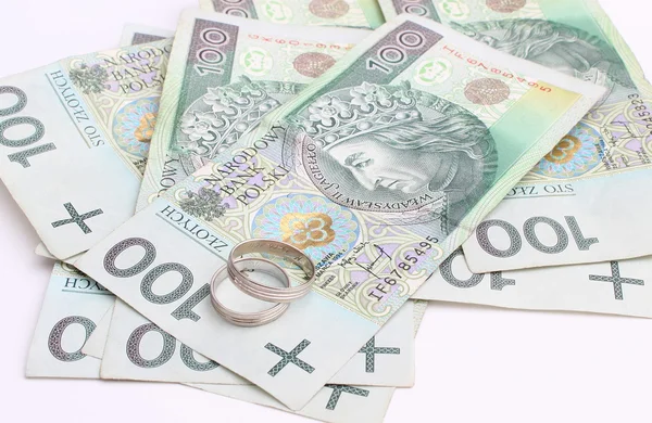 Anéis de casamento e dinheiro em um fundo branco — Fotografia de Stock