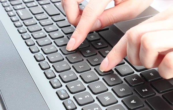 Female hand writing on a laptop keyboard — Stock Photo, Image