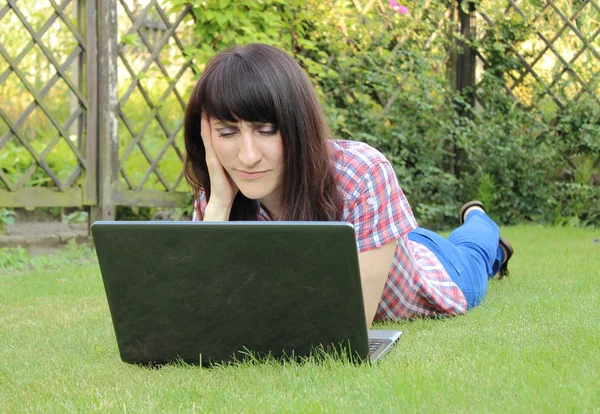 Woman with laptop in the sunny garden — Stock Photo, Image