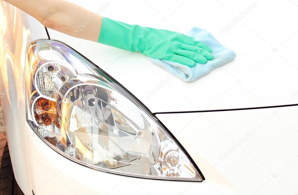 Woman hand with cloth cleaning car