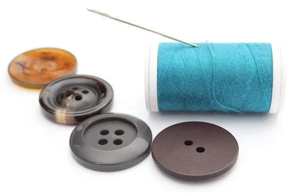 Sewing buttons and spool of thread on white background — Stock Photo, Image