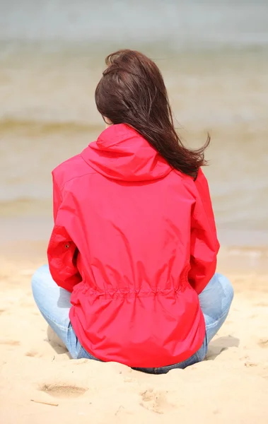 Mujer sentada en la playa y mirando al mar, hora de verano — Foto de Stock