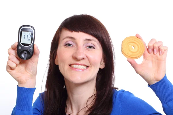 Lachende vrouw met glucose meter en taart op witte achtergrond — Stockfoto