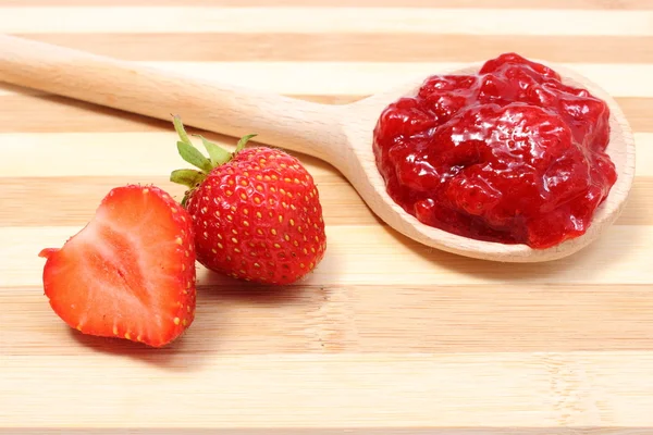 Mermelada de fresa en cuchara de madera con frutas frescas — Foto de Stock