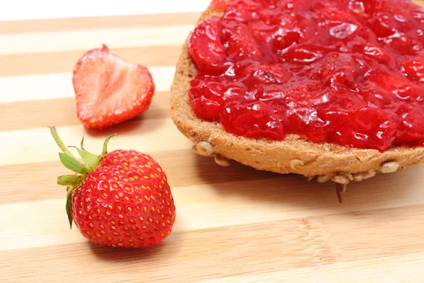 Wholemeal roll with strawberry jam and fresh fruits — Stock Photo, Image