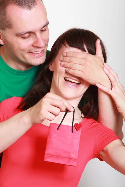 Homem dando um presente para mulher sorrindo surpreso — Fotografia de Stock