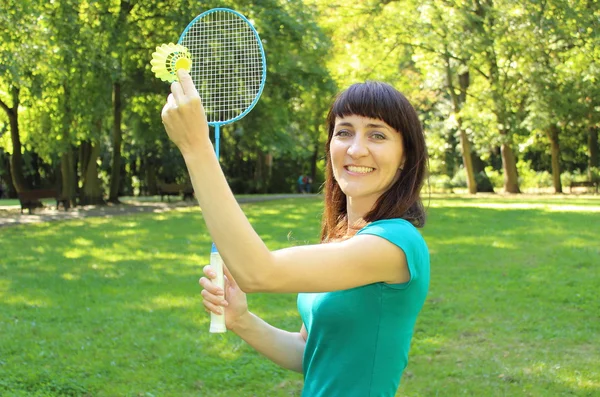 Mulher sorridente jogando badminton no parque de verão — Fotografia de Stock