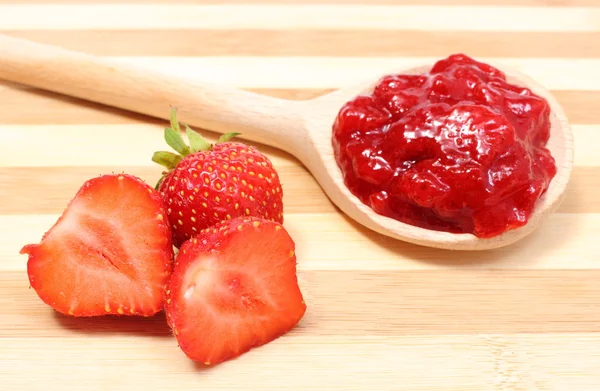 Mermelada de fresa en cuchara de madera con frutas frescas — Foto de Stock