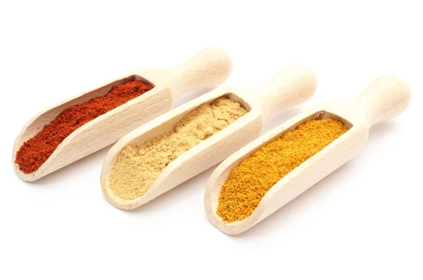 Three spices - curry, ginger and paprika - on wooden spoons — Stock Photo, Image