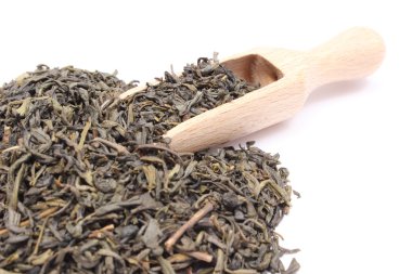 tahta kaşık kuru yeşil çayı yığını. Beyaz arka plan