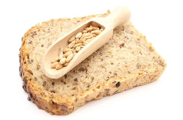 Natural wheat grain on wooden spoon and slice of bread — Stock Photo, Image