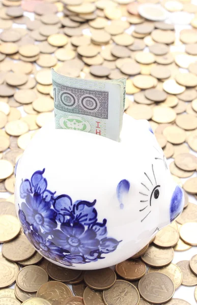 Piggy bank and money on heap of coins — Stock Photo, Image