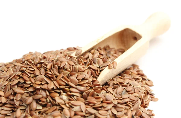 Heap of linseed with wooden spoon on white background — Stock Photo, Image