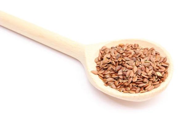 Heap of linseed with wooden spoon on white background — Stock Photo, Image