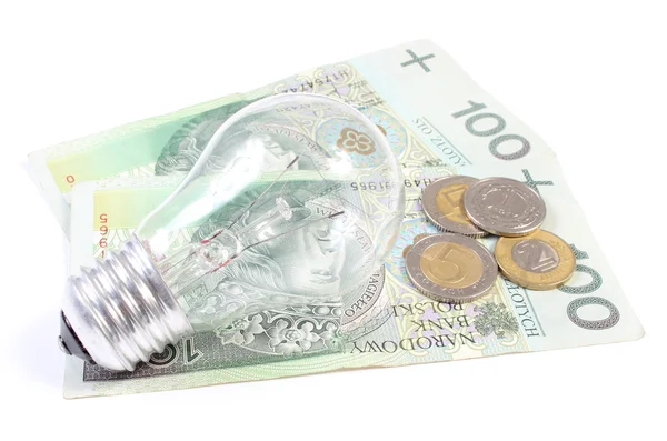 Žárovka ležící na hromadu papírových peněz. bílé pozadí — Stock fotografie