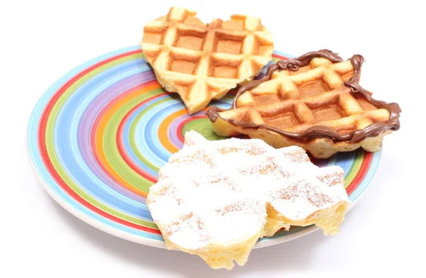 Waffles em forma de coração deitado em placa colorida. Fundo branco — Fotografia de Stock