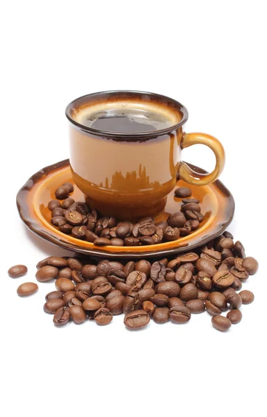 Куча кофейных зерен и чашка напитков — стоковое фото