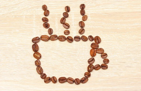 Grains de café en forme de tasse sur fond en bois — Photo