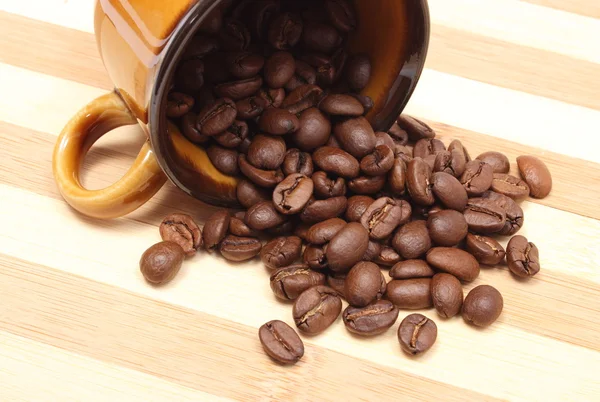 Umgestürzte Tasse und Haufen Kaffeekörner — Stockfoto