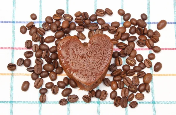 Herzförmiger Muffin mit Kaffeekörnern auf buntem Tuch — Stockfoto